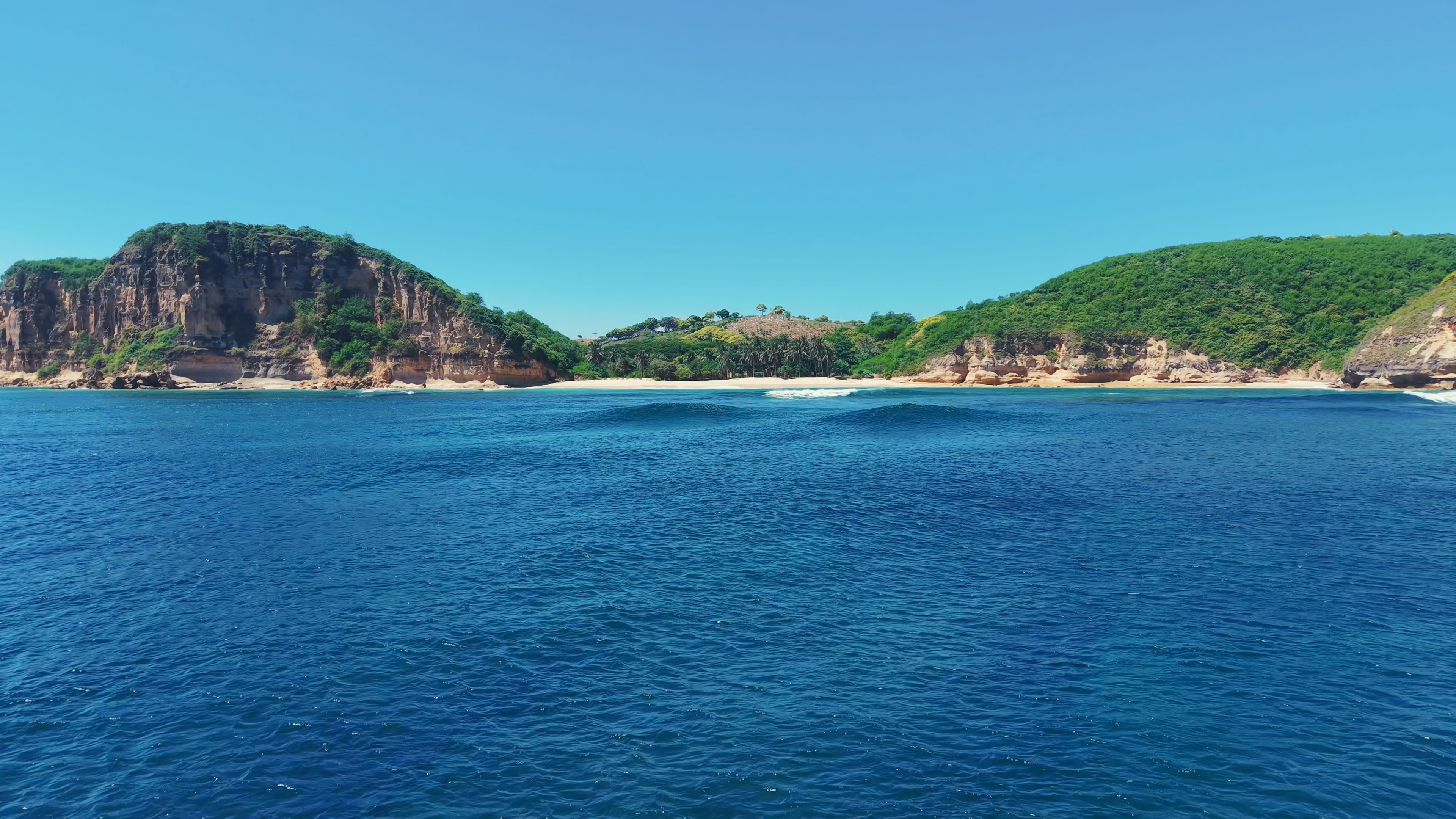 Ocean Heaven — panoramic view from the ocean showing the full beach and cliff setting