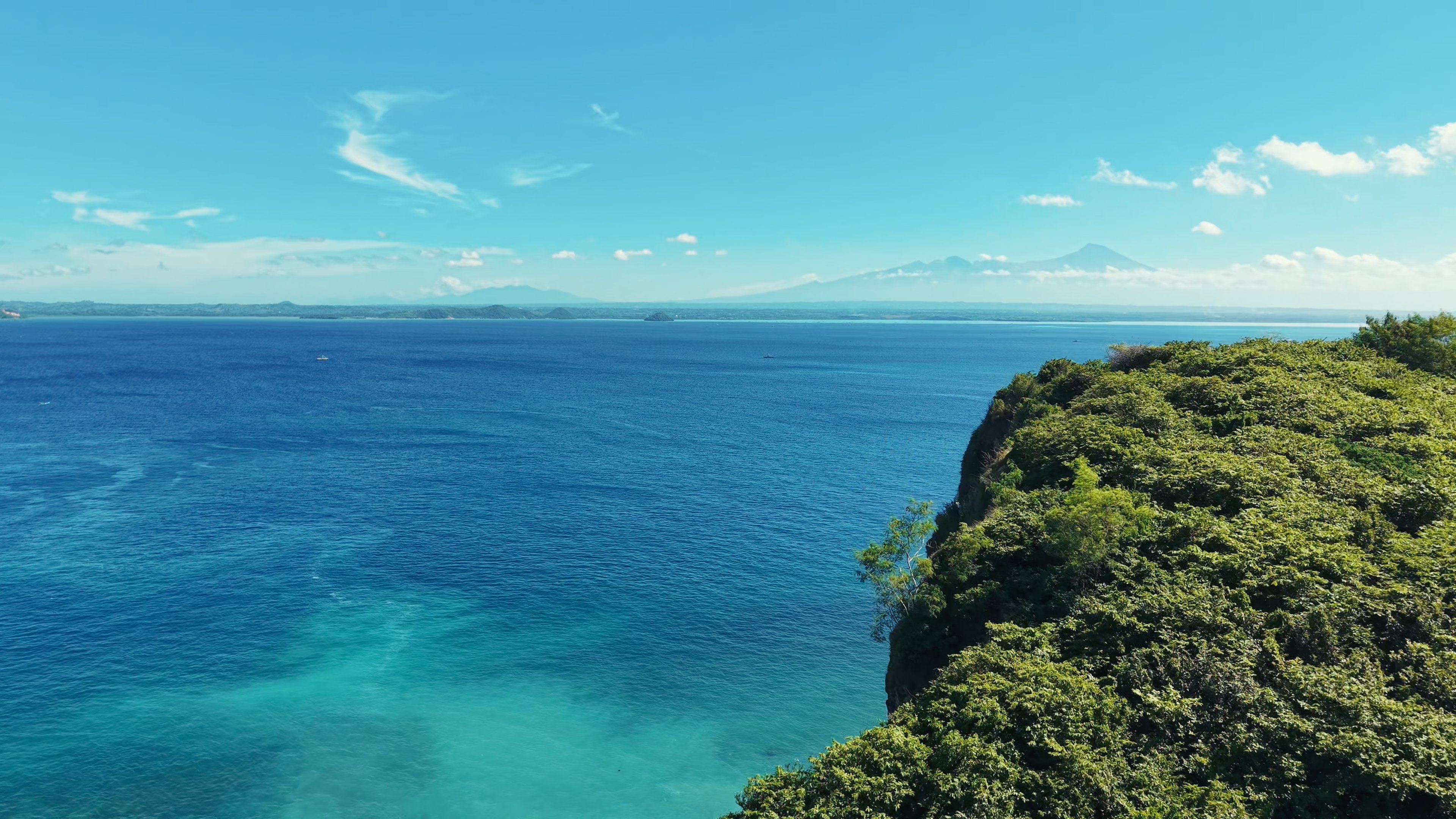 Ocean Heaven Cliffs — clifftop view with Mount Rinjani and turquoise ocean